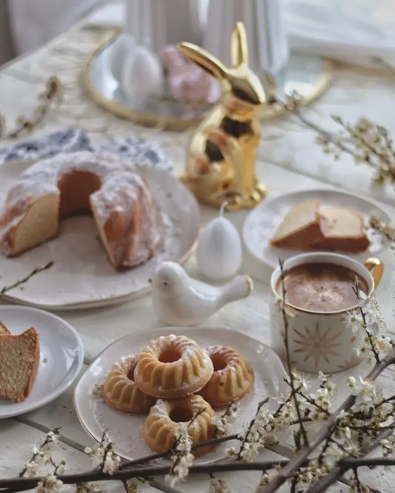 Wielkanocne babki - babka puchowa, małe babki piaskowe. Stół udekorowany kwitnącymi gałązkami i złotym króliczkiem