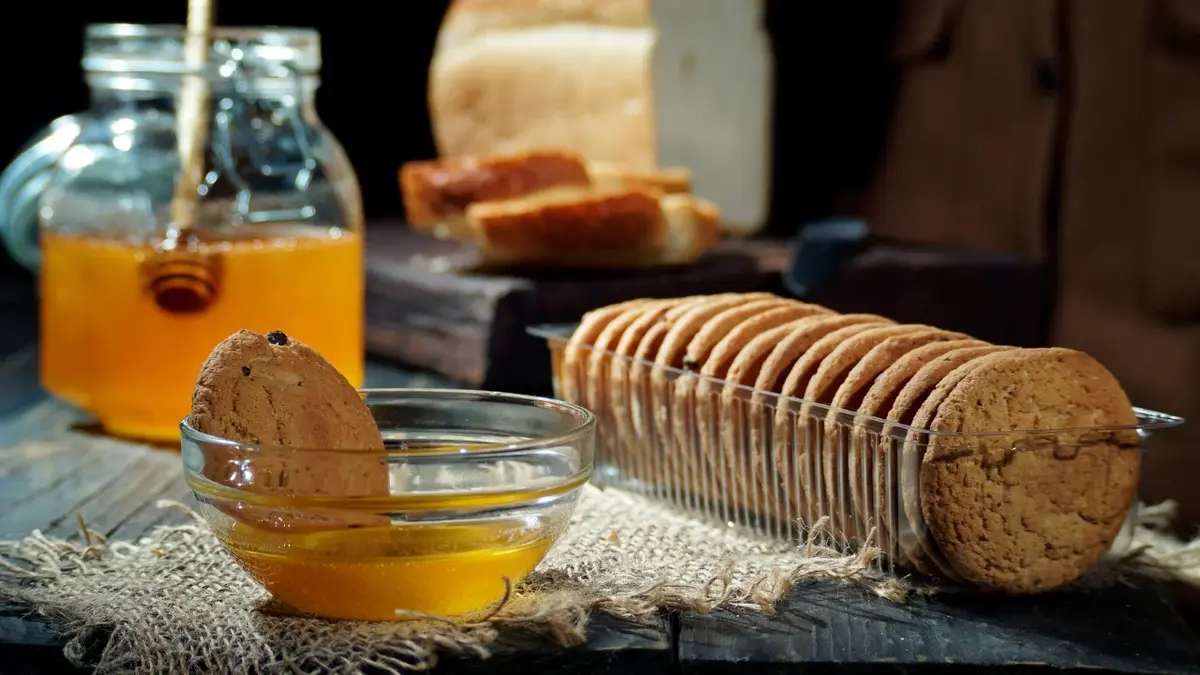 ciasteczka miód w miseczce i w słoiku z tyłu chleb