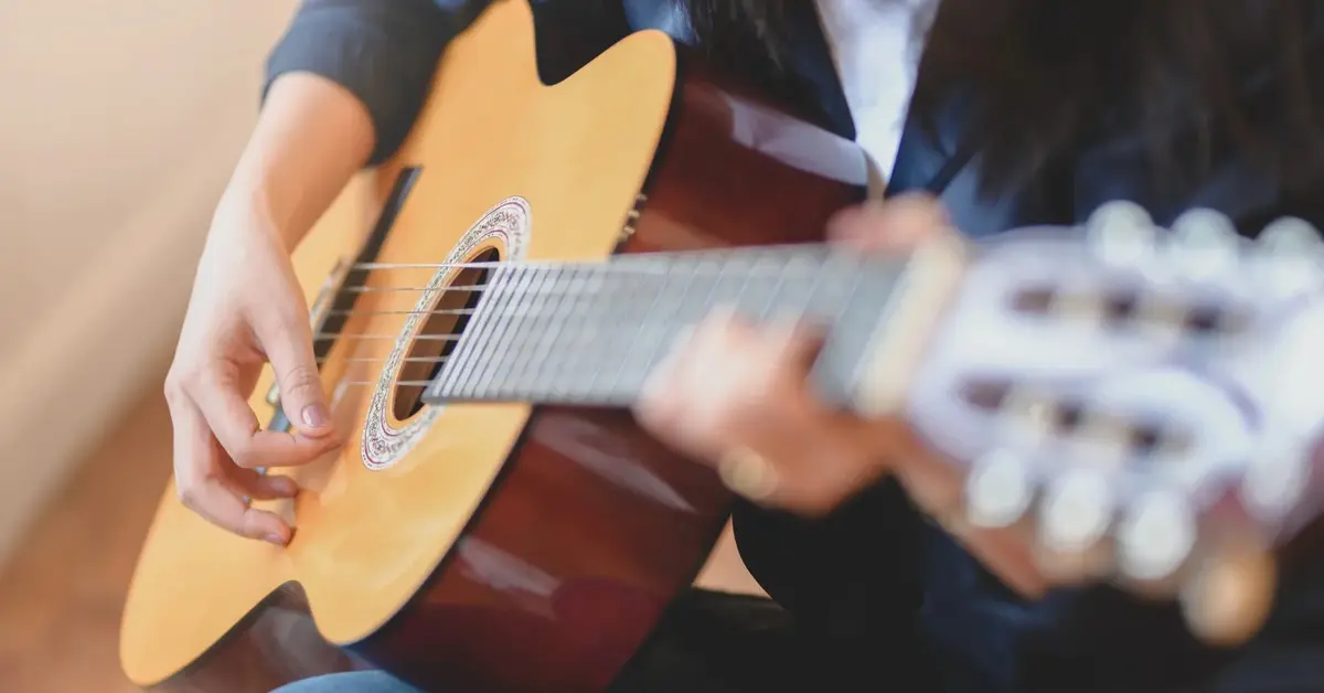 Osoba gra na gitarze klasycznej