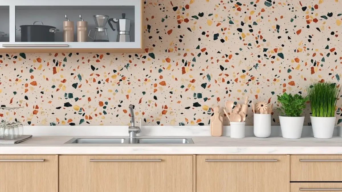 Backsplash w kuchni wyłożony różowym terrazzo w niebieskie, pomarańczowe i żółte cętki