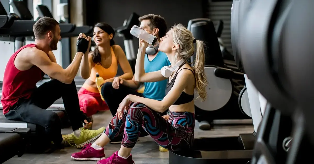 Radośni ludzie w siłowni po zakończonych zajęciach fitness