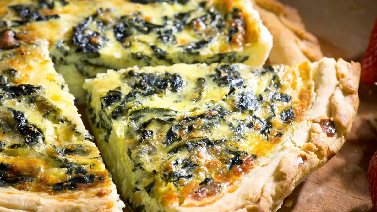 Quiche ze szpinakiem z wykrojoną i wysuniętą porcją 