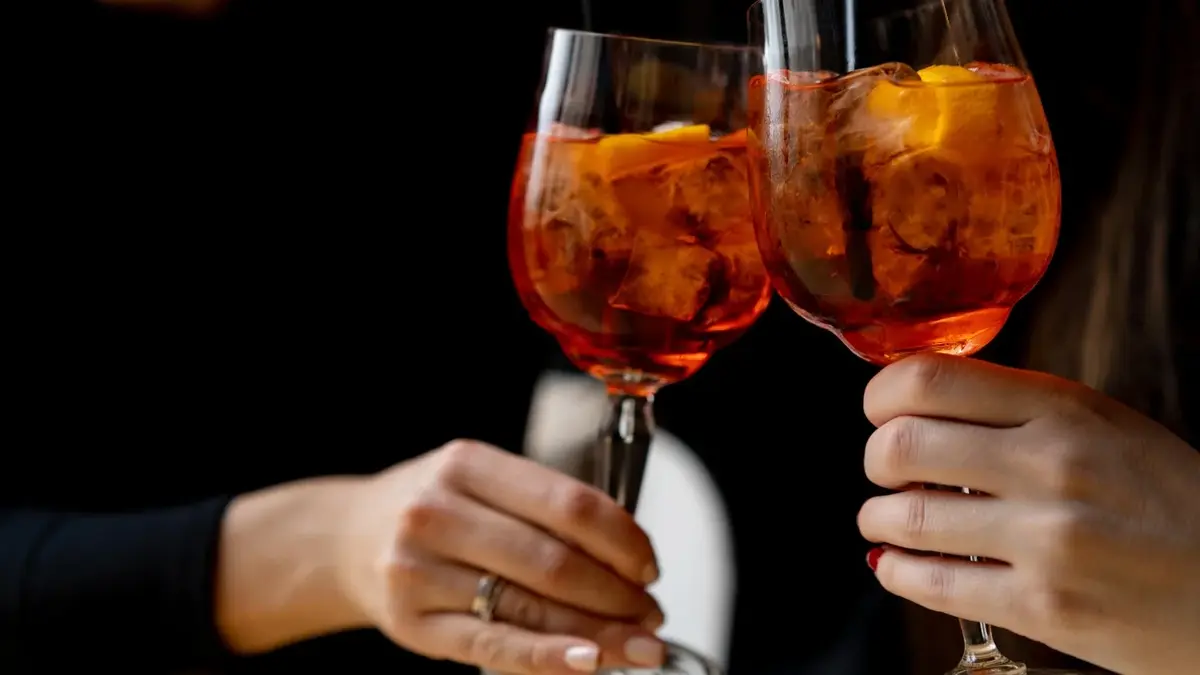 Aperol Spritz z lodem i pomarańczą w wysokich kieliszkach 