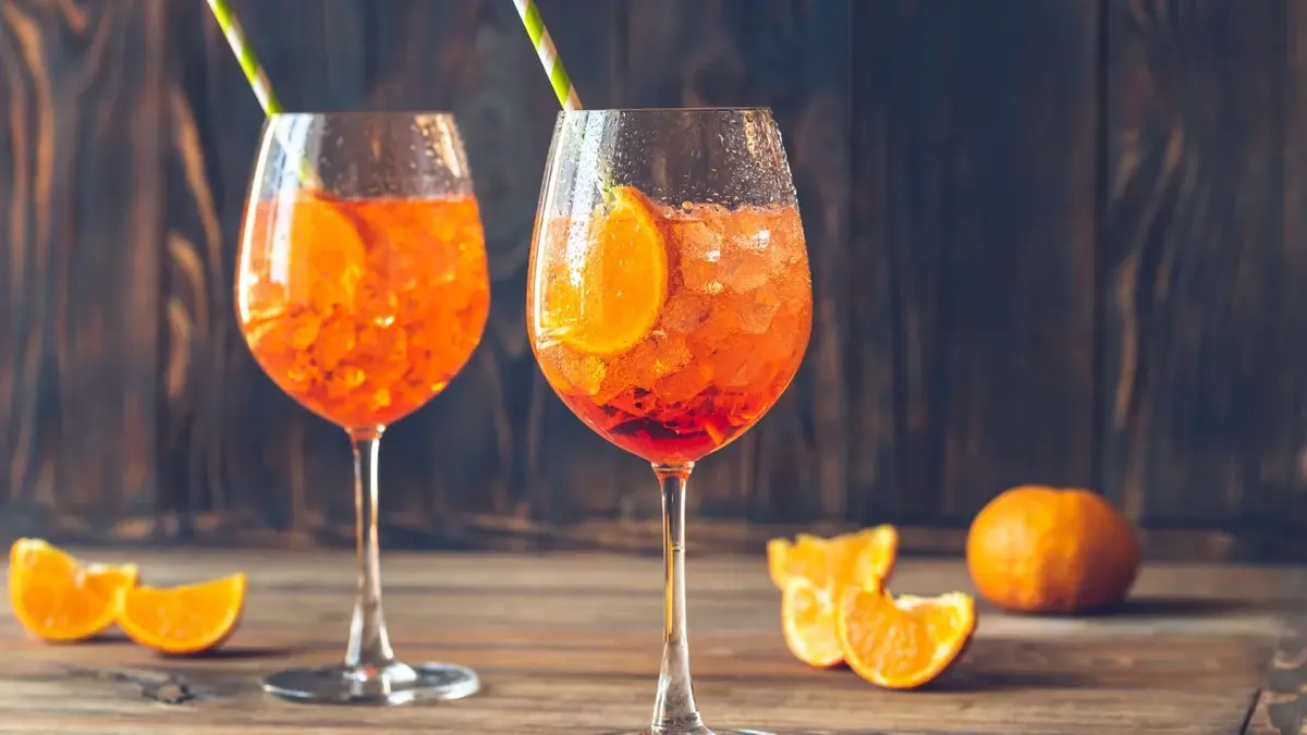 Aperol Spritz z lodem i pomarańczą w wysokich kieliszkach 