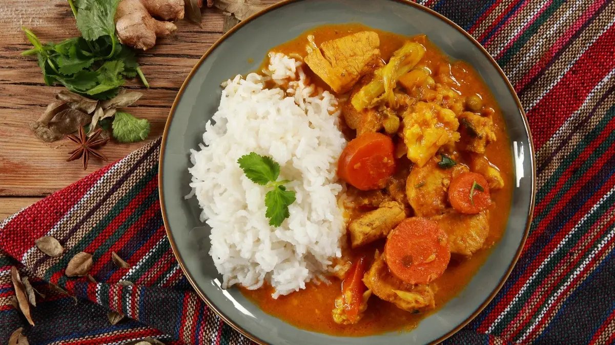 Curry z kurczaka z marchewką i ryżem w głębokim talerzu