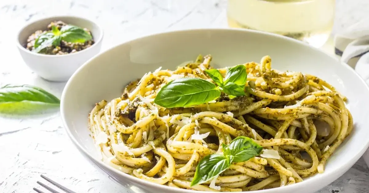 Spaghetti z pesto na białym głębokim talerzu 