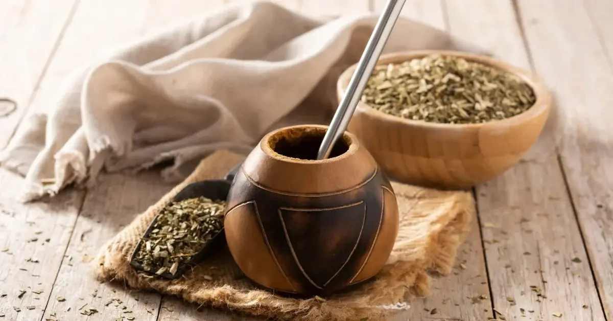 Yerba Mate w naczyniu do picia, obok miseczka z suszoną yerbą