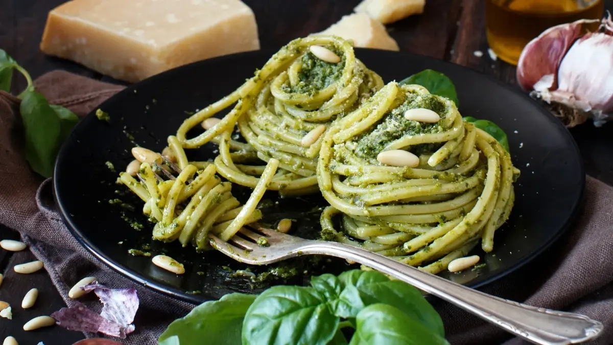 Spaghetti z pesto na czarnym talerzu 