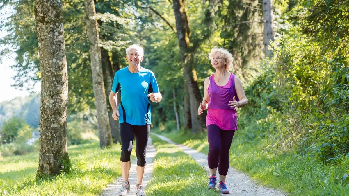 Para starszych osób uprawiających jogging w parku