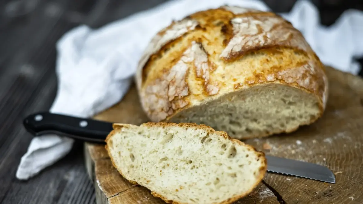 Chrupiący chleb na zakwasie obok kromka ukrojona z bochenka