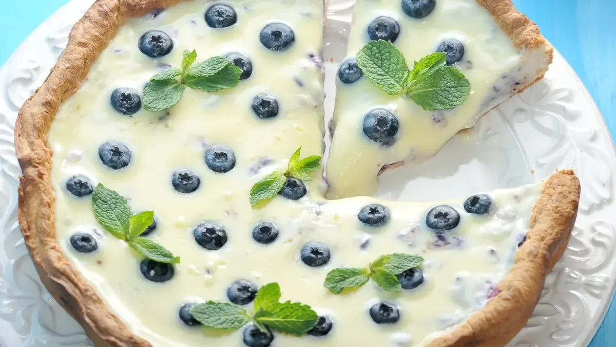 Tarta z białą czekoladą i borówkami na niebieskim tle