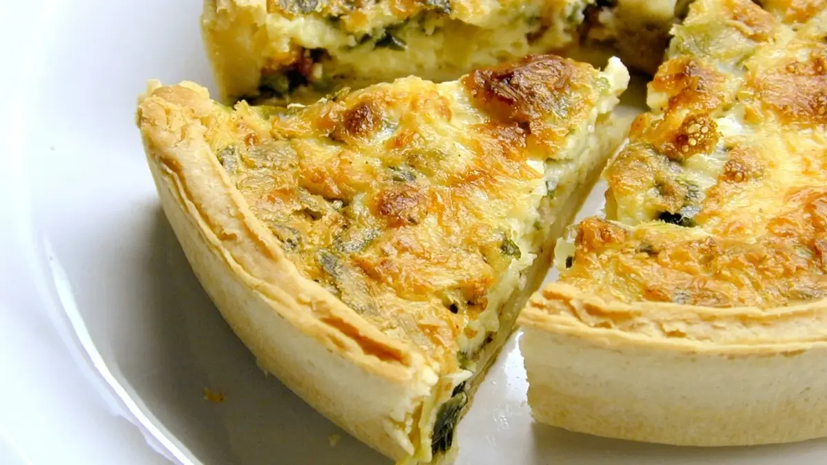 Quiche z brokułami i serem na białym talerzu